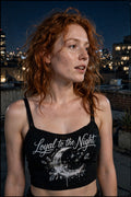 Women's black underbust crop top with a front-only print: silver cursive script reading 'Loyal to the Night' over a graffiti-splattered crescent moon with small crystal accents.
